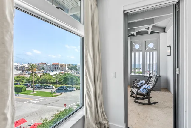 a view of a room with a floor to ceiling window and potted plants
