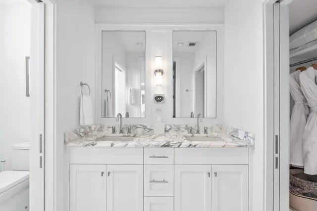 a bathroom with double sink and a mirror