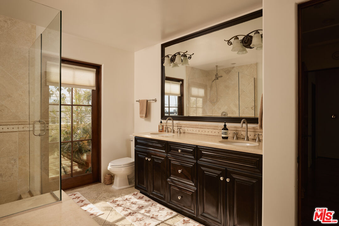 908 17th Street, Unit 8 Santa Monica, CA 90403 - Photo 11 of 15 a bathroom with a double vanity sink mirror and shower