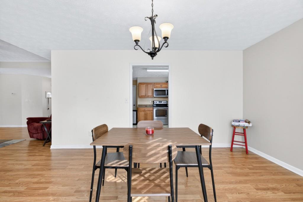 701 Muirfield Drive Winder, GA 30680 - Photo 14 of 35 a view of a dining room with furniture wooden floor and chandelier