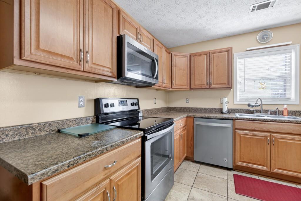 701 Muirfield Drive Winder, GA 30680 - Photo 18 of 35 a kitchen with stainless steel appliances granite countertop a sink stove and microwave