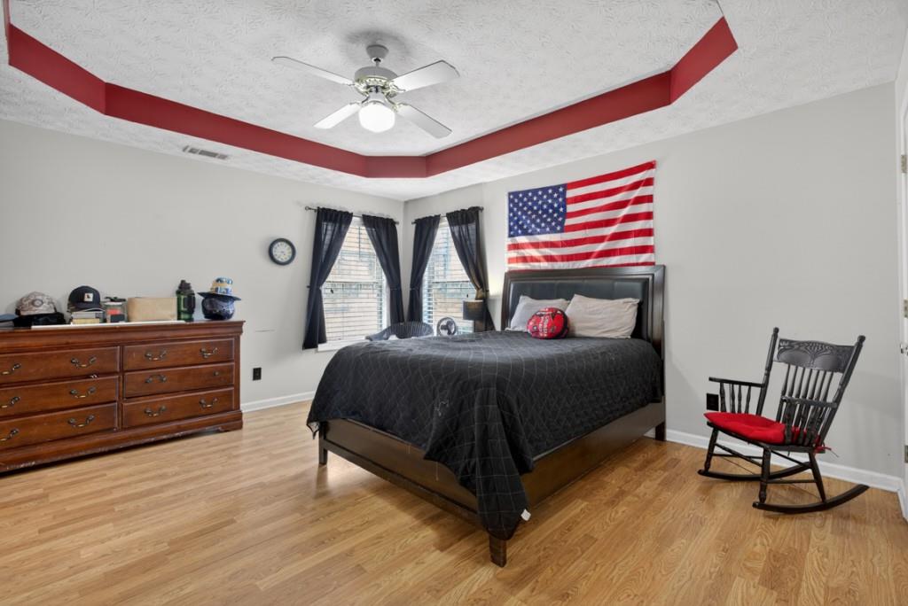 701 Muirfield Drive Winder, GA 30680 - Photo 25 of 35 a bedroom with a bed and a chandelier