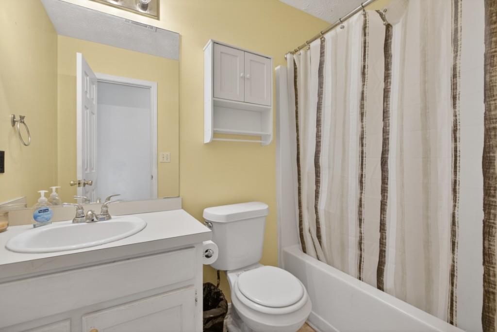 701 Muirfield Drive Winder, GA 30680 - Photo 33 of 35 a bathroom with a toilet a sink and a shower