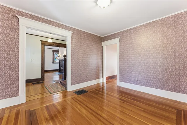 a view of a hallway with wooden floor and closet