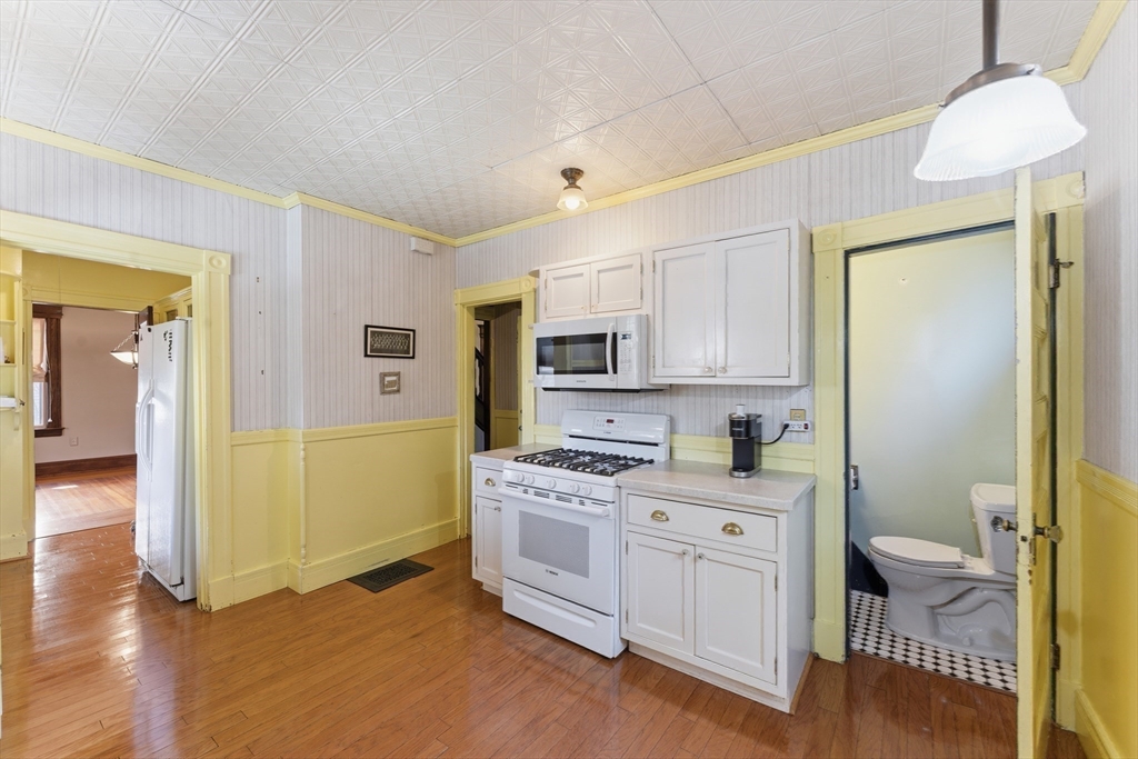 106 Magnolia Terrace Springfield, MA 01108 - Photo 15 of 42 a kitchen with a sink a stove cabinets and wooden floor