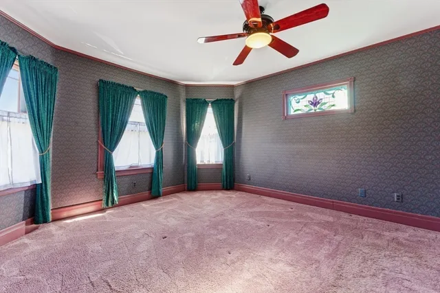 an empty room with windows and fan