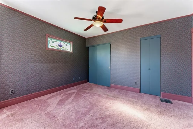 a bedroom with a bed and a lamp on dresser