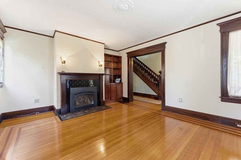 106 Magnolia Terrace Springfield, MA 01108 - Photo 9 of 42 a view of an empty room with wooden floor fireplace and a window