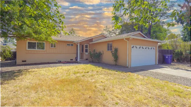 a view of a house with a yard and garage