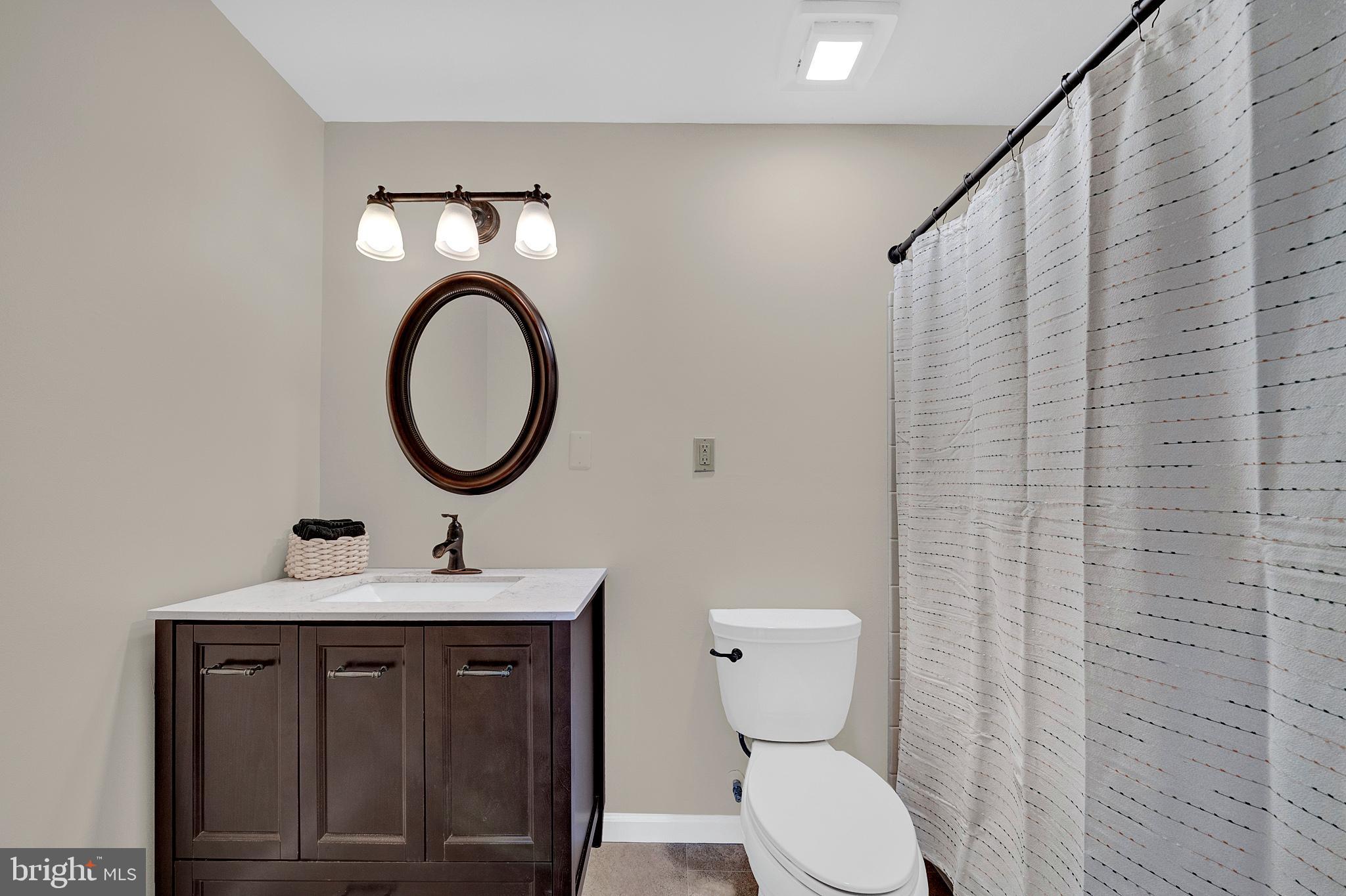 335 Silvia Street Ewing, NJ 08628 - Photo 19 of 25 a bathroom with a toilet a sink and a mirror