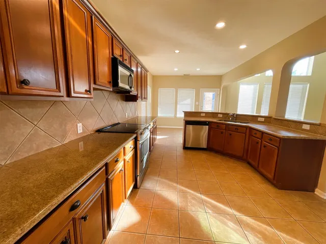 a kitchen with granite countertop wooden cabinets and a stove top oven