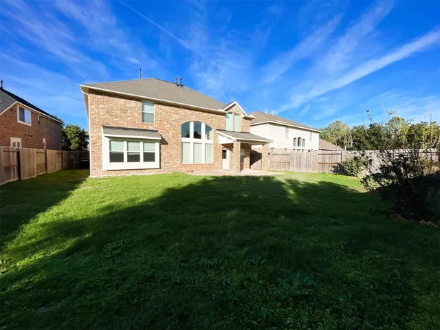 a view of a house with a big yard and large trees