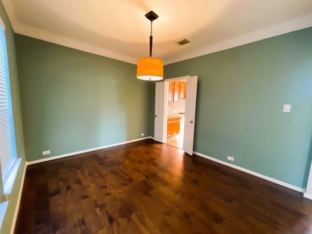 a view of empty room with window and chandelier