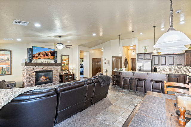 210 Talon Court Ivins, UT 84738 - Photo 13 of 60 Living area featuring ceiling fan, lofted ceiling, a stone fireplace, and recessed lighting