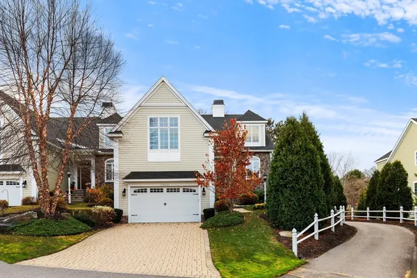 a view of a white house next to a yard and trees