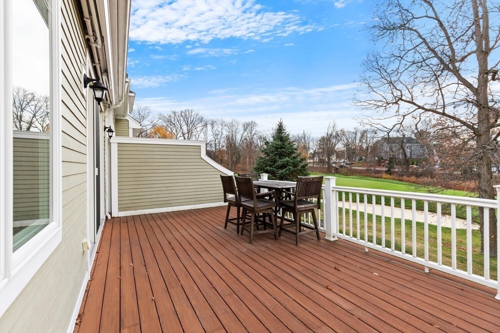 37 Crenshaw Lane, Unit 37 Andover, MA 01810 - Photo 18 of 40 a view of a roof deck with table and chairs a barbeque with wooden floor and fence