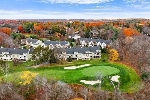 an aerial view of a town with swimming pool and mountains
