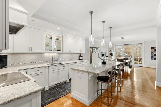 a kitchen with stainless steel appliances granite countertop a sink a stove and a wooden floors