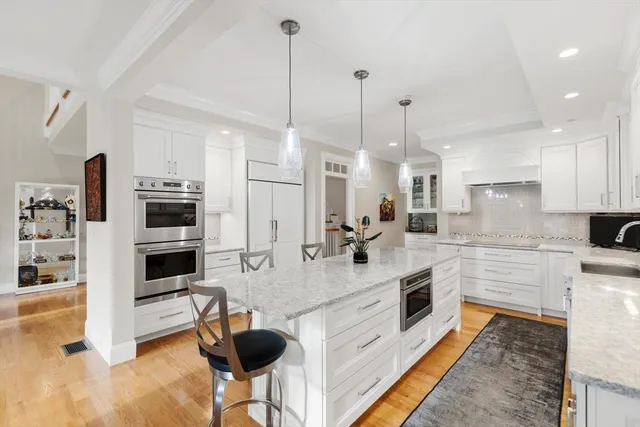 a large kitchen with kitchen island a large counter top space appliances and cabinets