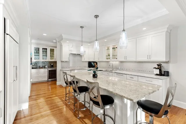 a kitchen with a dining table chairs sink and cabinets