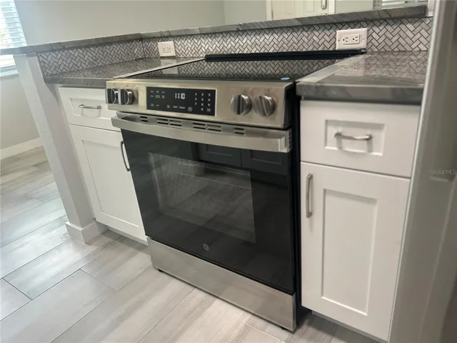 a stove top oven sitting inside of a kitchen