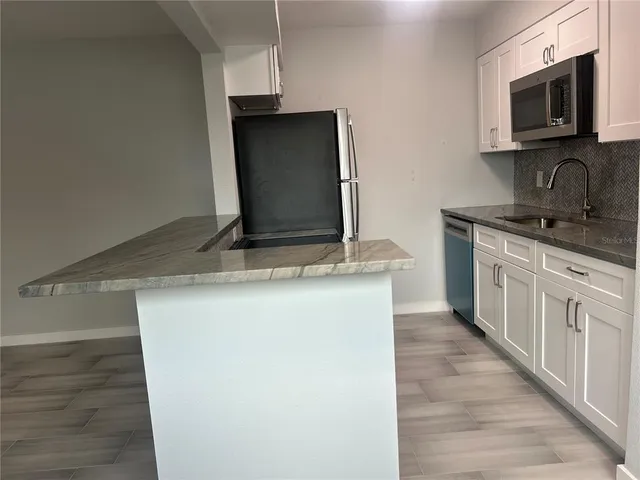 a kitchen with stainless steel appliances granite countertop a sink and a microwave