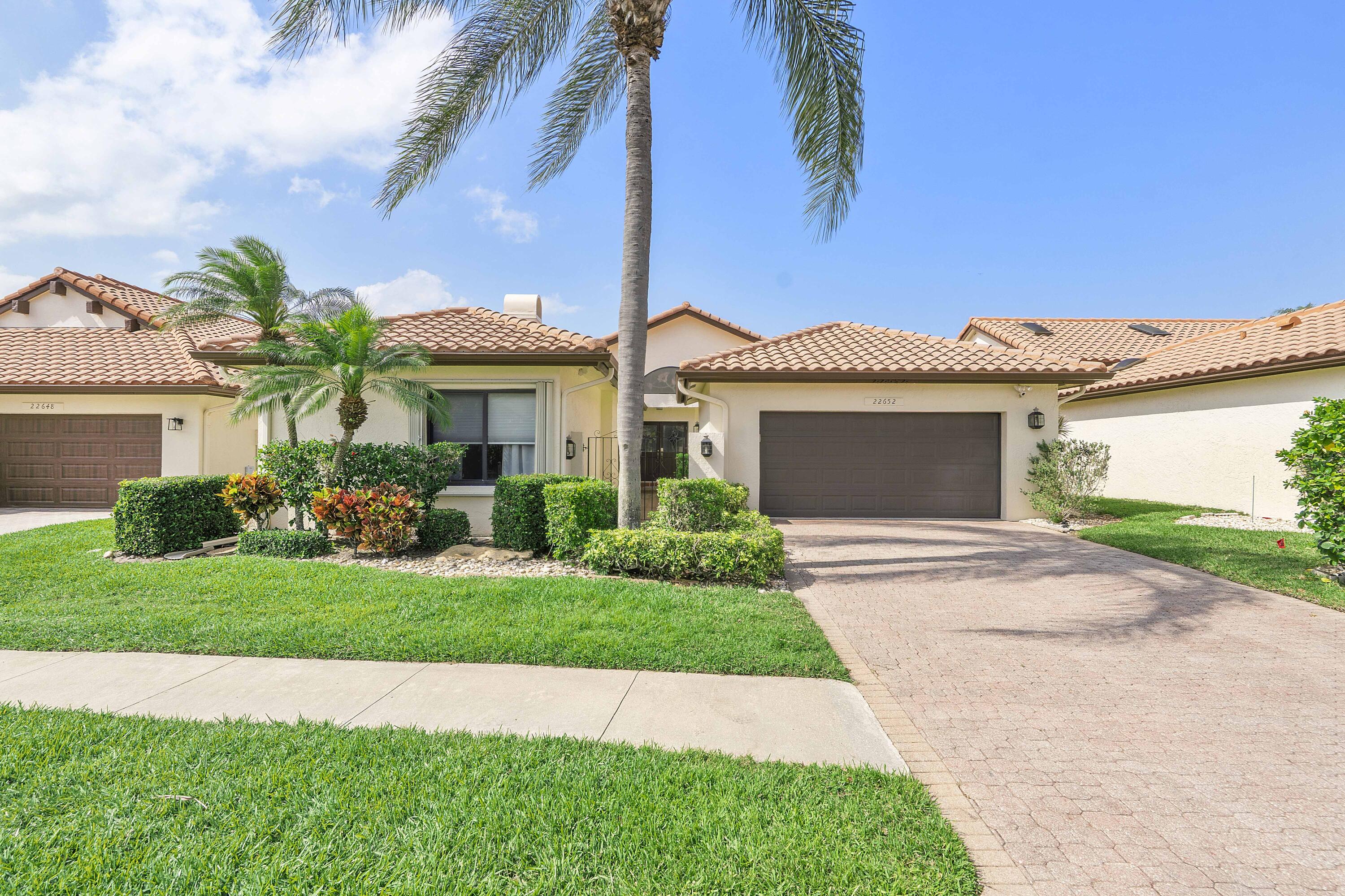 a front view of a house with a garden and yard