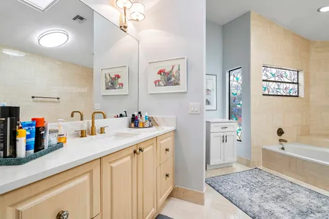 a bathroom with a tub sink and a mirror