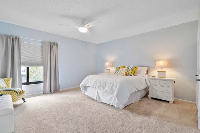 a spacious bedroom with a bed and a lamp