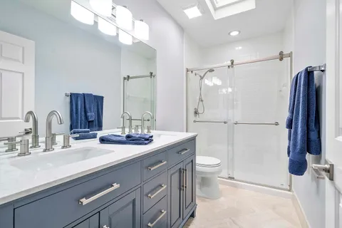 a bathroom with a double vanity sink mirror and toilet