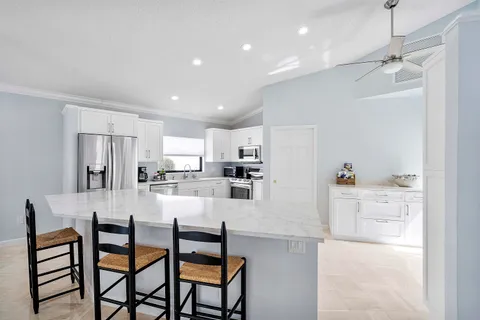 a kitchen with kitchen island wooden cabinets and refrigerator