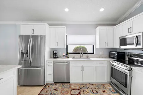 a kitchen with cabinets stainless steel appliances and a counter space