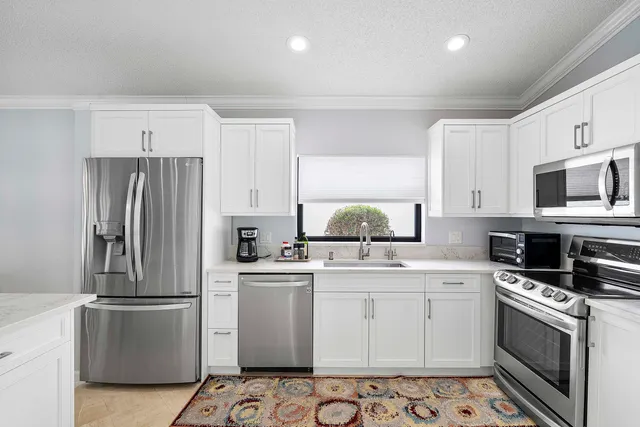 a kitchen with cabinets stainless steel appliances and a counter space