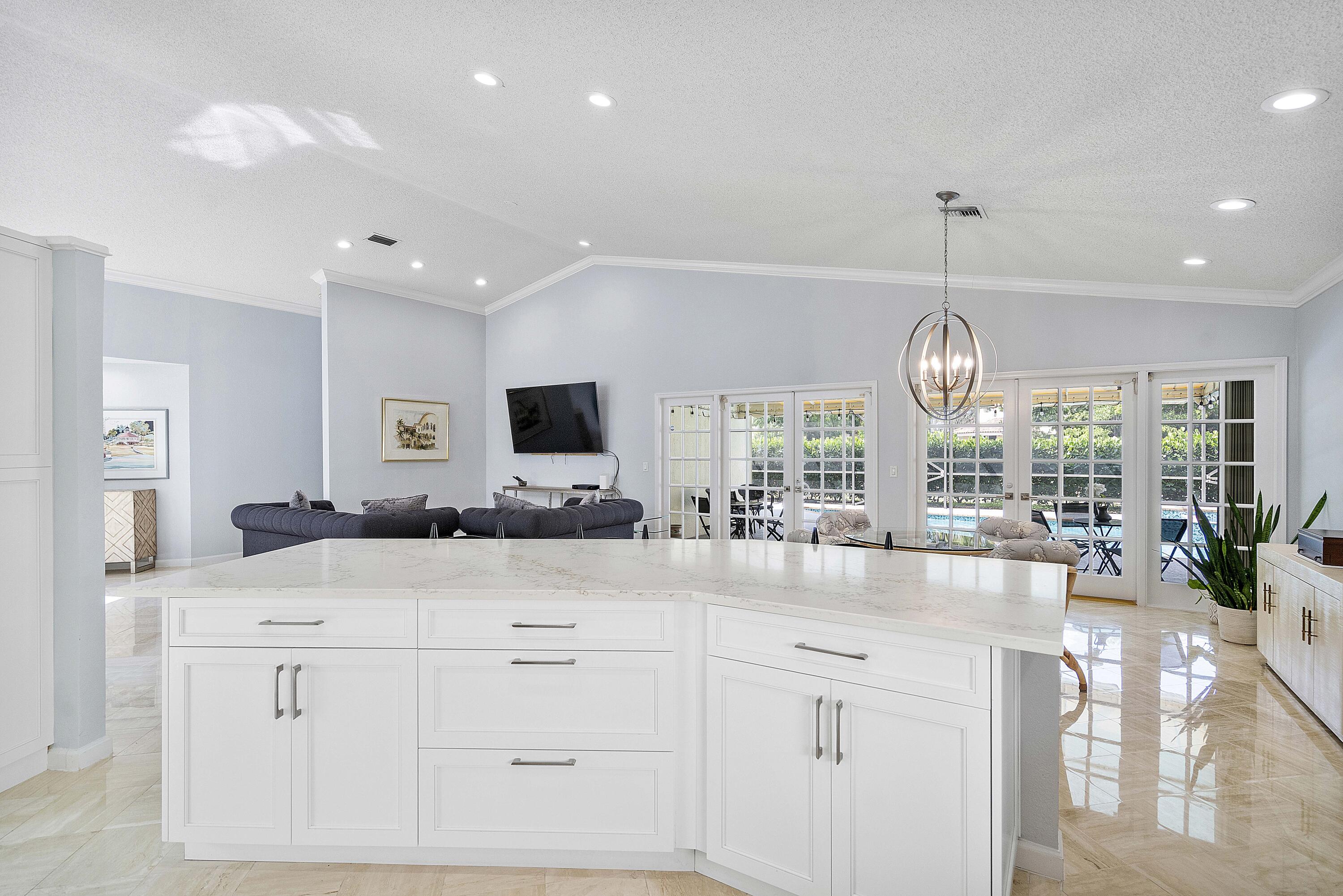 22652 Esplanada Circle Boca Raton, FL 33433 - Photo 9 of 44 a large kitchen with kitchen island a chandelier and living room view