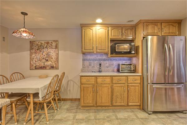 6 Random Lane Andover, MA 01810 - Photo 8 of 30 a kitchen with stainless steel appliances granite countertop a refrigerator a sink dishwasher a dining table and chairs with wooden floor
