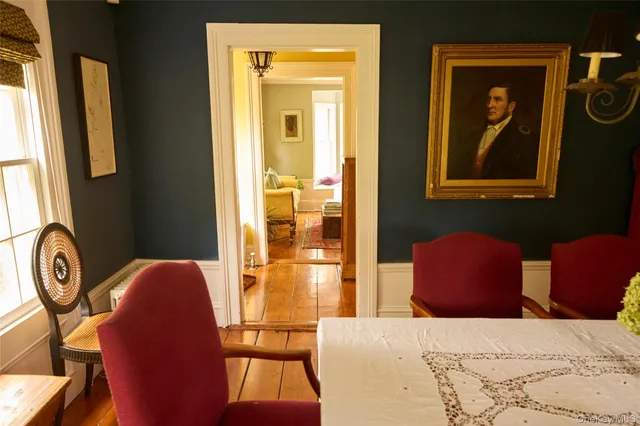 a bedroom with two beds and next to a window