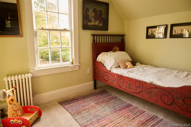 a bed sitting in a bedroom next to a window