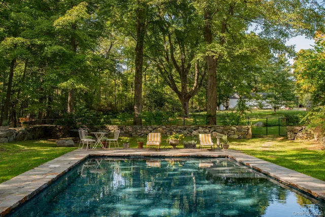 a view of swimming pool with a yard and large trees