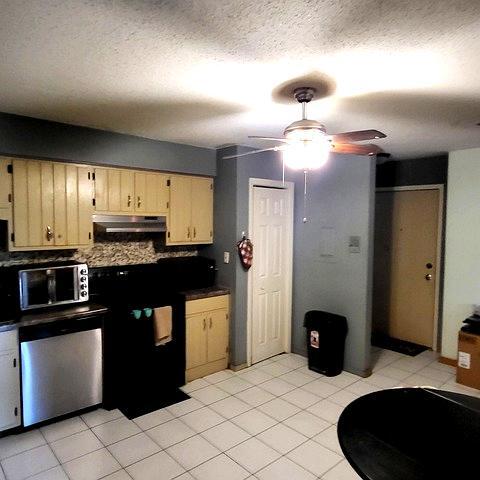 212 Madison Street, Unit 3B Joliet, IL 60435 - Photo 3 of 11 a kitchen with granite countertop a refrigerator and a stove top oven