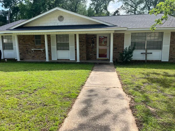 a front view of a house with a garden