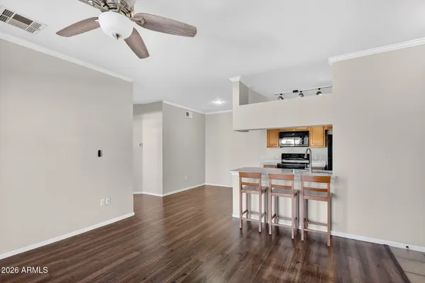 an empty room with wooden floor fireplace and windows