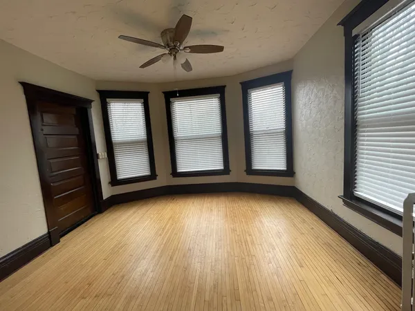 wooden floor in an empty room with a window