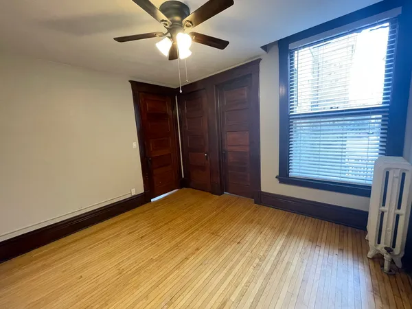 a view of empty room with a fireplace and wooden floor