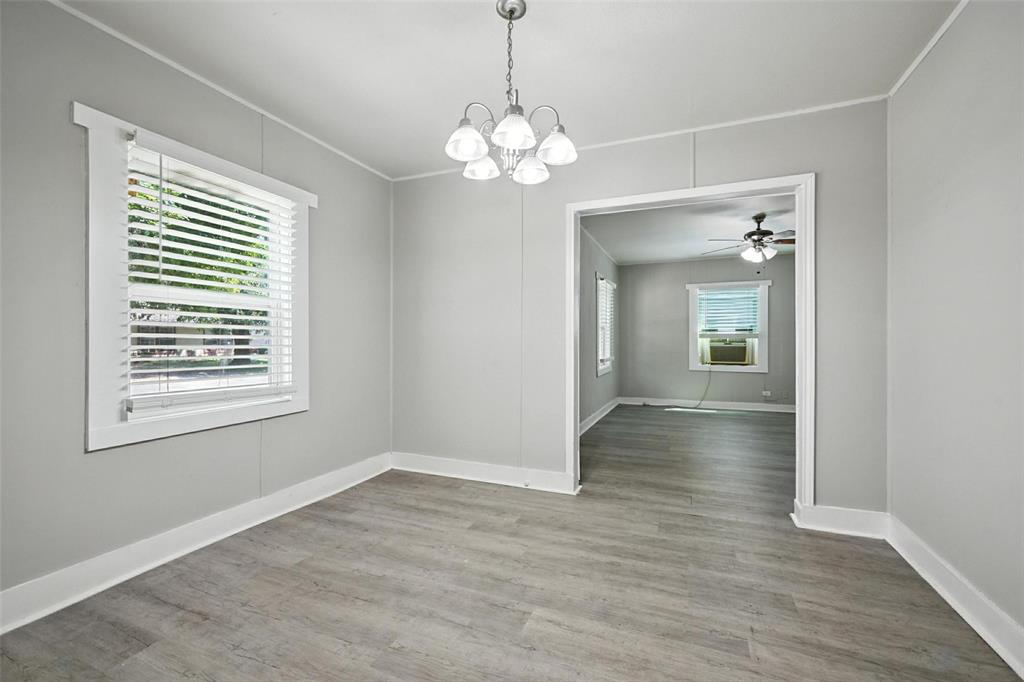204 Graham Avenue Bonham, TX 75418 - Photo 6 of 21 Unfurnished dining area with a chandelier, light wood-style floors, ceiling fan, and crown molding