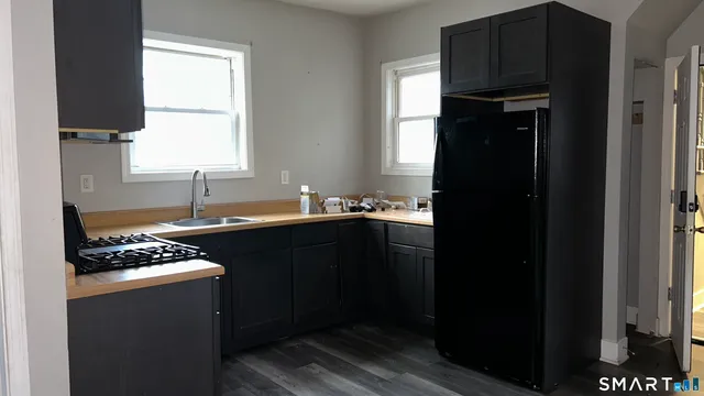 a kitchen with a sink a stove cabinets and a refrigerator
