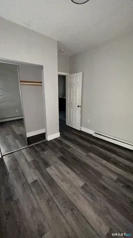 an empty room with wooden floor and white wall