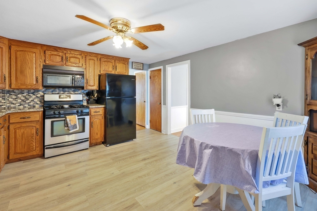 104 Oregon Street Springfield, MA 01118 - Photo 10 of 32 a kitchen with stainless steel appliances kitchen island granite countertop a refrigerator a stove a sink dishwasher and a microwave with wooden floor