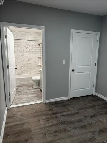 a view of empty room with wooden floor and window