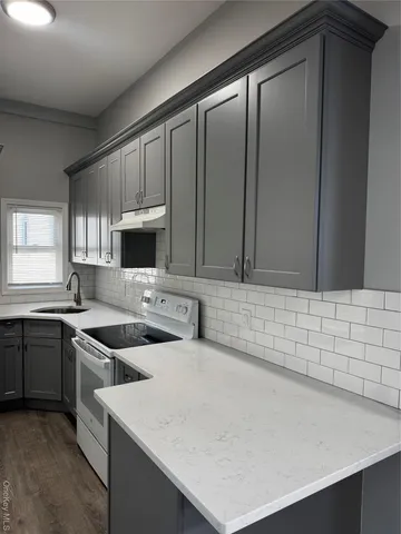 a kitchen with stainless steel appliances a sink stove and cabinets