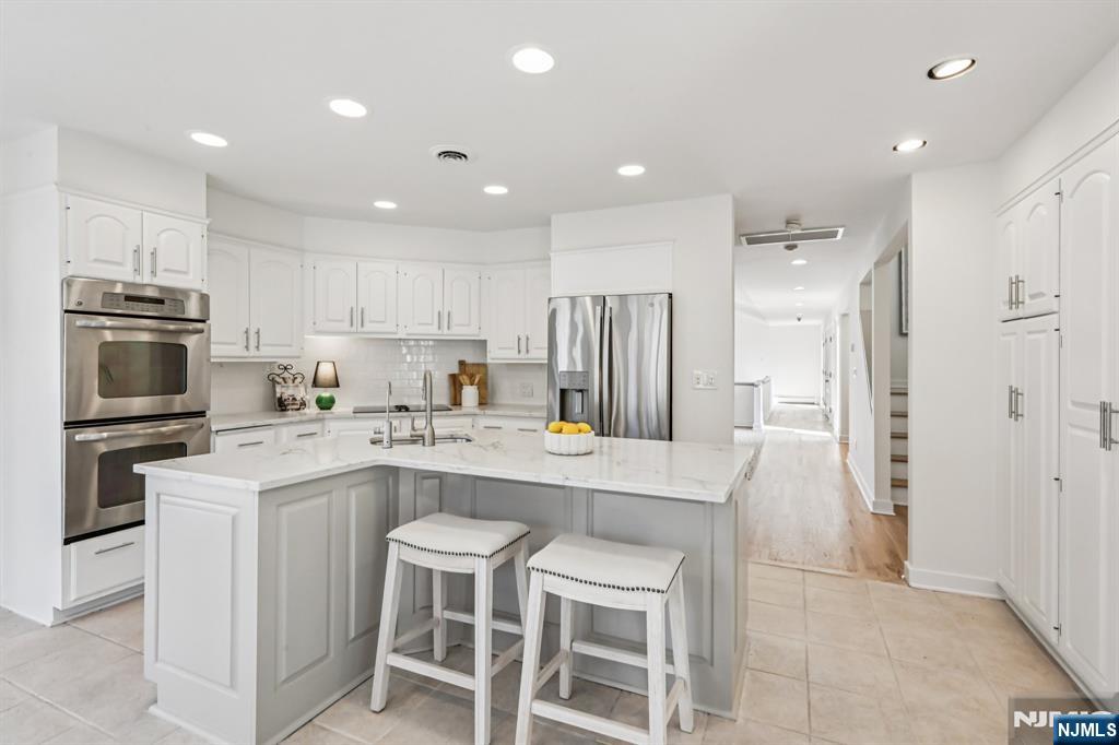 11 Carlough Road Upper Saddle River, NJ 07458 - Photo 14 of 41 a kitchen with kitchen island white cabinets and stainless steel appliances